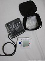Photo showing digital blood pressure monitor, arm cuff, and carrying case closed