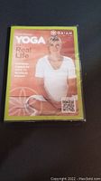 Front cover of sealed DVD showing woman in yoga pose and title 'Yoga for Real Life'