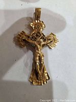 Front view of the cross pendant showing Jesus figure and radiating design