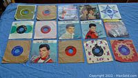 Overview of all 15 vintage 45 RPM records laid out showing various sleeve designs and condition.