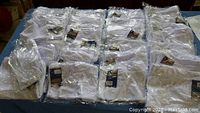 Several individually wrapped white Champro football shorts displayed in rows, showing quantity and packaging.