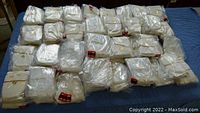 53 pairs of Mason junior fingerless sports gloves individually packaged in plastic, laid out on a blue surface