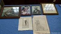 Group photo of three framed vintage photos and one painting frame on table with two vintage drawings below.