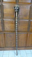 Full view of the carved wood skeleton skull head stick showing its length and spine design.