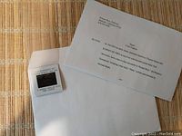 Image showing the Warner Bros printed press kit letter and slide in plastic mount lying on a wooden surface.