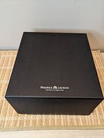 Outer black box with Maurice Lacroix logo printed on top, showing unopened packaging for the watch box set.