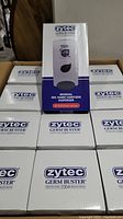 Boxed manual gel hand sanitizer dispensers by Zytec Germ Buster, showing multiple boxes stacked together with one box upright displaying the product illustration and branding.