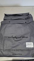 Grey fabric bag with Weighted Idea branding containing weighted cotton sheet