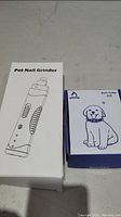 Photo of two boxes, one labeled Pet Nail Grinder, the other labeled Bark Collar A12 with a dog illustration.