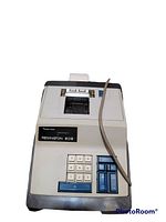 Remington 208 calculator with numeric keypad, function keys, and paper roll on top, shown from front angle with power cord attached.