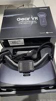 Photo of Samsung Gear VR headset and controller with original box beneath them.