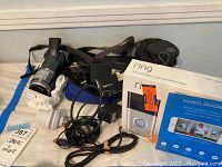Overview of lot contents including Sony camcorder, cameras, cables, and boxed Ring video doorbell
