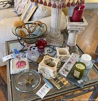 Overview of the items on a glass table including candle holders, glass bowl, Christmas decorations, and decorative pieces.