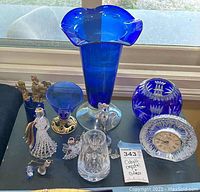 Photo of all items including cobalt large vase, smaller vases, multiple angel figurines, crystal clock, and decorative glass pieces
