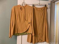 Full front view of beige handmade ladies suit jacket and matching skirt on hangers