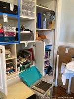 Overview of shelving unit with various office supplies including binders, file folders, and stationery items