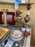 Photo shows the plaster bust, two ornate candle holders, a round stone ashtray labeled Made in Italy, a red child's toy bus, cream and sugar set, and framed picture.