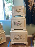 Front view of stacked wooden shabby chic boxes showing floral artwork on each box