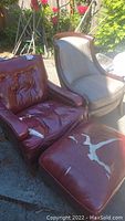 Photo showing one maroon leather chair, beige fabric chair, and maroon leather ottoman outdoors with visible damage.