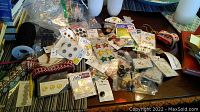 Overview of assorted buttons, ribbons, and trims laid out on a table showcasing variety in size, color, and packaging.