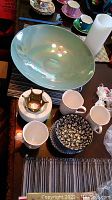 Photo of the dishware set displaying large iridescent green bowl, Lenox coffee cups, small patterned plates and bowls, colorful espresso cups with matching saucers