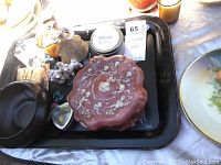 Items displayed on a black metal tray showing pink Incolay stone box, Arnart figurine, candles, and small decorative containers