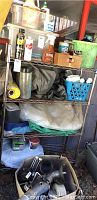 Metal wire rack with assorted cleaning, gardening, and maintenance items scattered on shelves