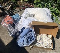 Photo showing white blanket, blue blankets, fabric seat covers with pastel children's prints, and a fabric steamer