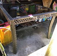 Front and side view of rattan table with tinted glass top and umbrella hole.