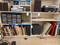 Bookshelves with various art and music-related books along with stereo and audio equipment above.