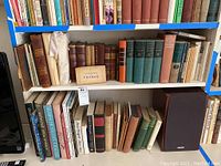 Three shelves of assorted books, various titles and sizes
