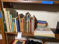 Books on wooden shelf showing multiple vintage children's books with titles visible on spines and covers.