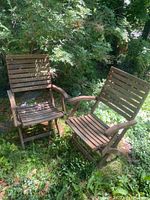 Two teak folding chairs positioned outdoors on grass