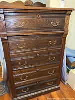 Front view showing the five drawers with brass handles and decorative keyholes.