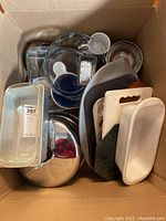 Photo showing the contents of bakeware and kitchenware including several glass bowls, loaf pans, cutting boards and wooden salad bowls.