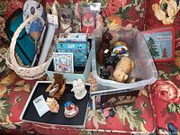 Overall lot displayed on floral couch including basket, lunch bag, postcards, puzzles, and figurines