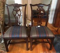 Pair of Ethan Allen Chauncey side dining chairs showing carved backrests and striped upholstered seats. Condition issues visible including scratches and wear on wood and upholstery.
