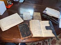 Overview of two books, two photographs, bullet mold and envelope on table