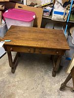 Full view of walnut desk showing top surface, both drawers, and curved legs with connected stretcher.