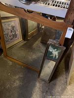 Large maple framed mirror with curved top edge, showing wear and stains.