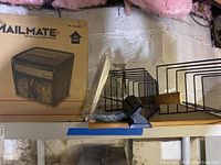 Items on basement shelf including shredder box, file organizers, 3-hole punch, ruler, and memo board