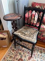 Photo showing vintage chair with upholstered seat next to round wooden side table.