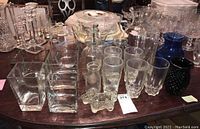 Wide view of all glass items showing milk bottle, vases and small bottles on table