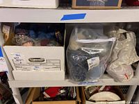 Box shelf with various bags and boxes of yarn and packing supplies.