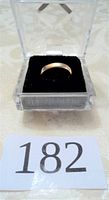 Ring displayed upright in clear plastic display box on black velvet base