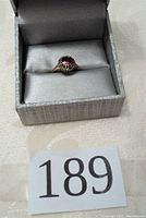 Overall view of the ring inside a gray jewelry box.