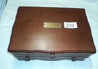 Top view of wooden jewelry box showing polished surface with a small scratch and brass plate.