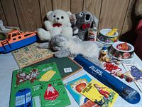 Photo showing plush puppets (bear, koala, bunny), Pepsi can radio, Auios recorder, plastic boat, McDonald's grow chart, patches, Donald Duck and Miss Piggy figures, Winnie the Pooh bowls, books, and vintage puzzle