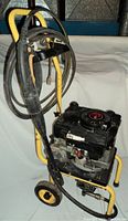 Side view of Karcher 588 GM pressure washer showing yellow frame, black engine, and coiled spray hose with handle.