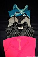 Four Lululemon exercise tops laid out flat, showing variety of colors and styles.